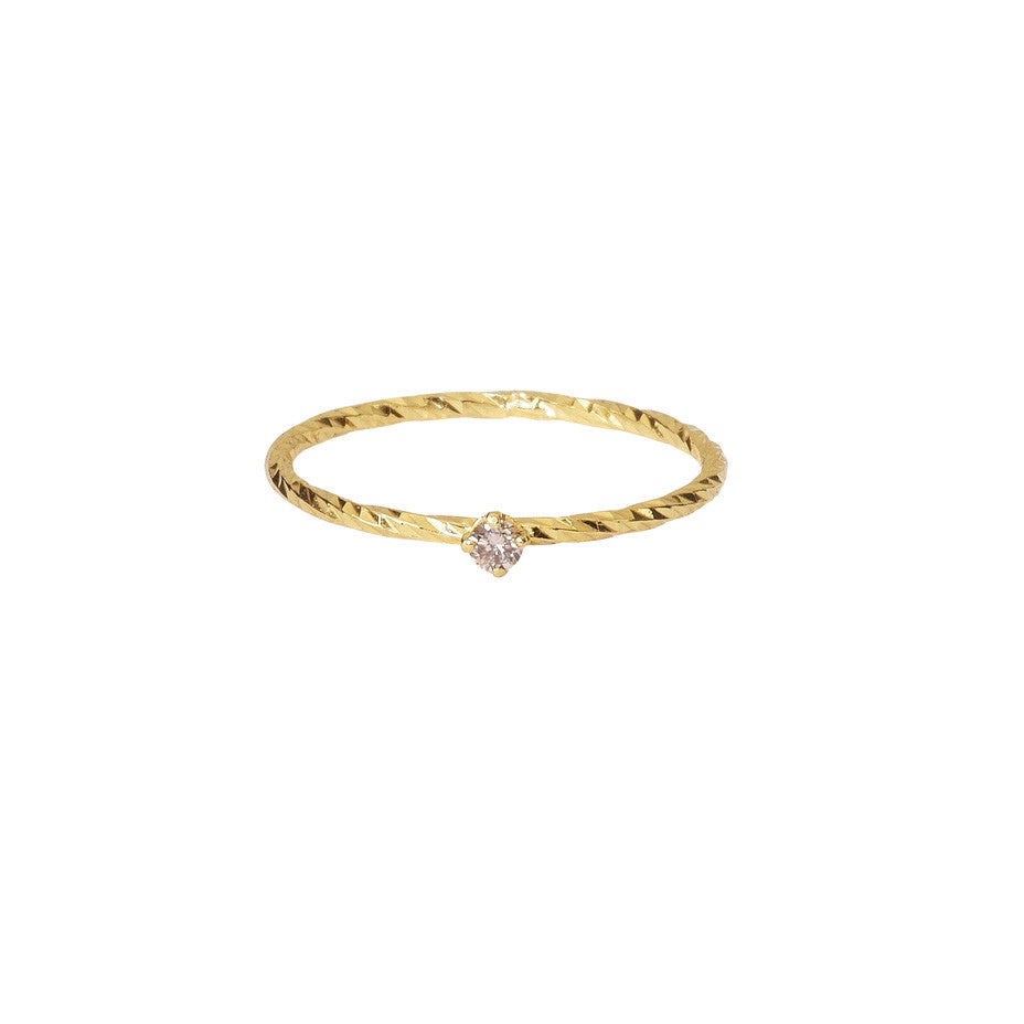 A sparkling band stacking ring in gold with a claw set champagne diamond.
