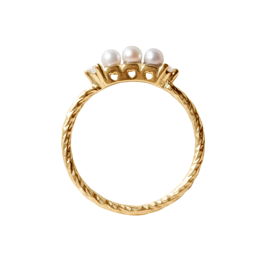 Pearl five stone birthstone ring with two white diamond side stones on a textured gold band. Sideview showing three cut out hearts on the stone setting.