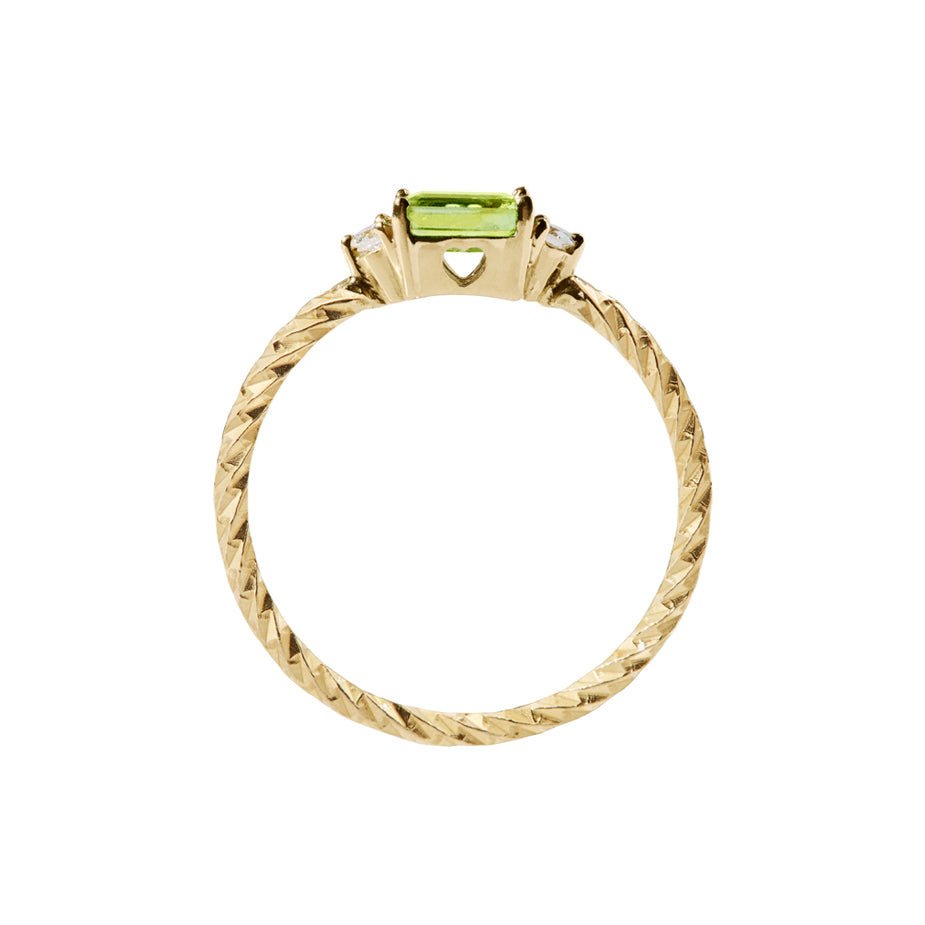 Peridot trilogy birthstone ring with two white diamond side stones on a textured gold band. Sideview showing a cut out heart on the stone setting.
