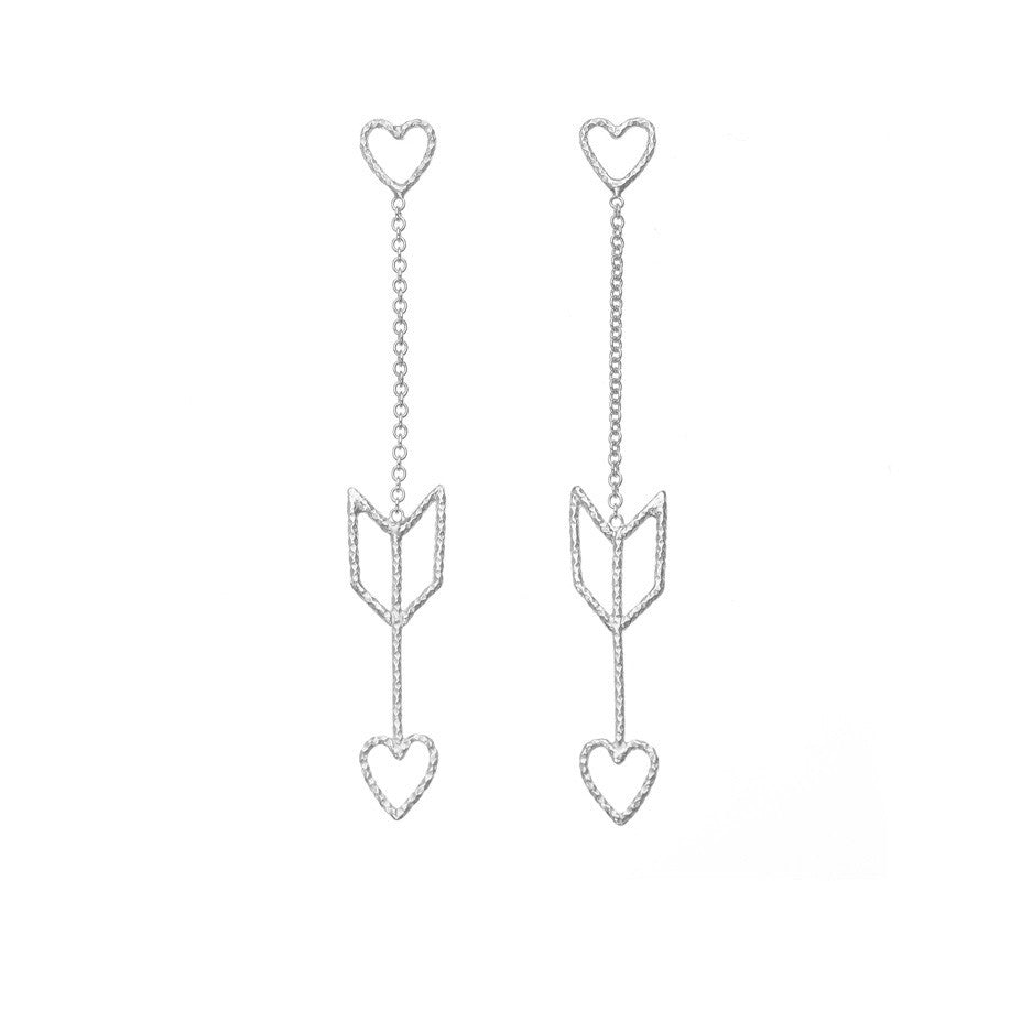Arrow Of Love earrings in silver. The heart and arrow are attached to each other by delicate silver chain.