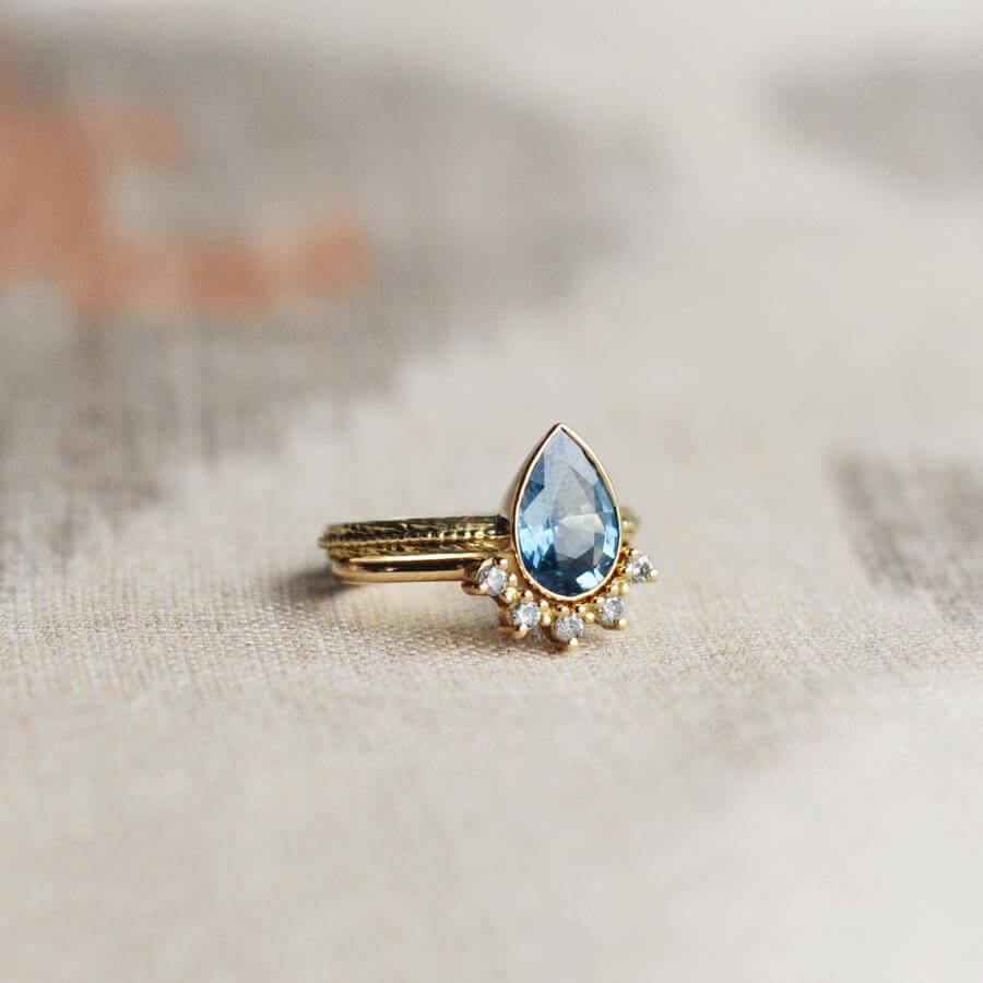 The pear shaped Harmony engagement ring with a blue grey sapphire, combined with a tiara wedding band with salt & pepper diamonds.