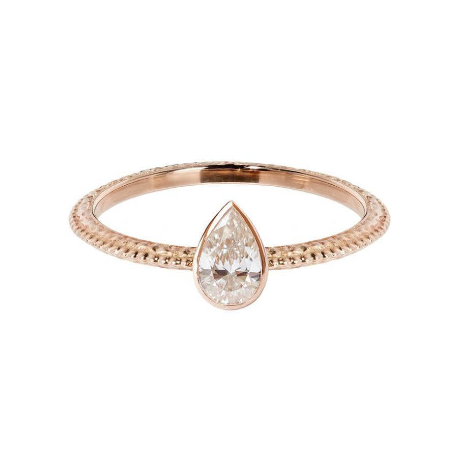 The Harmony engagement ring with a pear shaped white diamond which is bezel set. The textured band has a beautiful beaded line running down the centre. Made from 18 carat rose gold. 