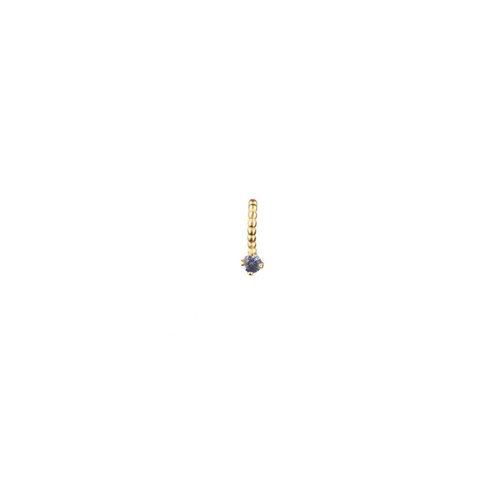 Light blue sapphire charm with beaded bail in gold.