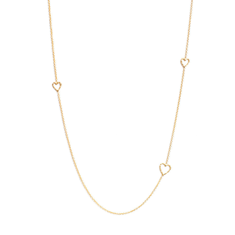 Follow Your Heart Long necklace in gold, featuring textured cut out hearts inserted into a delicate chain.