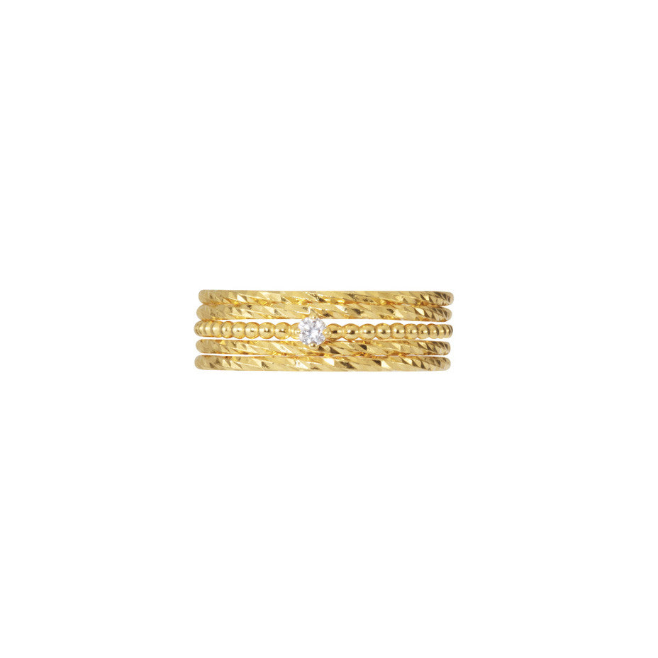 Single Diamond Stacking set in gold, fashioned from beaded and sparkling bands and a white diamond.